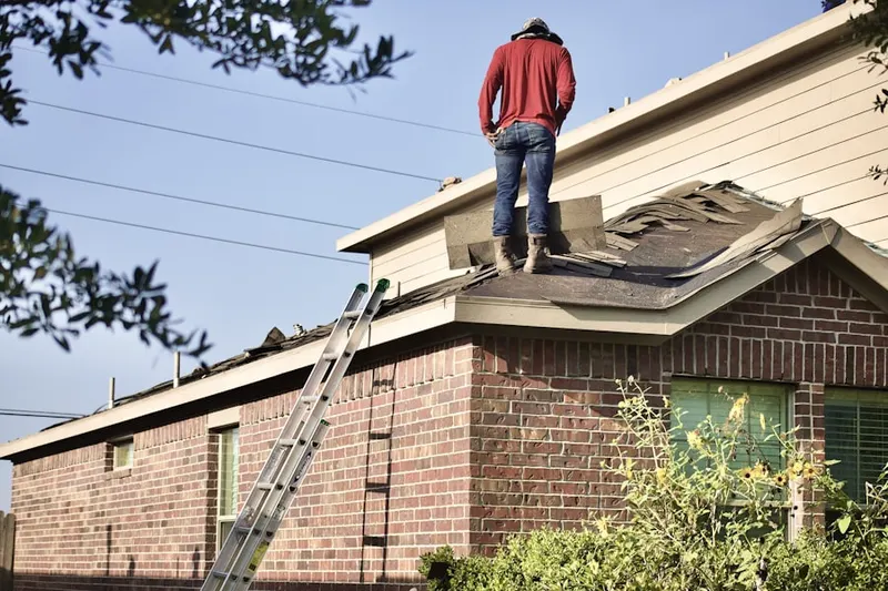 Professional roofer working on a residential roof in Ishpeming